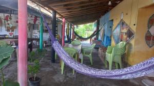a porch with a hammock and a table and chairs at POUSADA ATINS MELo in Atins