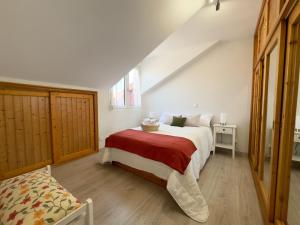 ein Schlafzimmer mit einem großen Bett mit einer roten Decke in der Unterkunft El Alba - 30602 in Somo