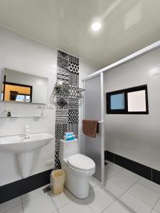 La salle de bains blanche est pourvue de toilettes et d'un lavabo. dans l'établissement Little Butler B&B, à Huxi