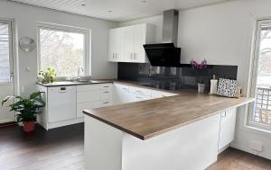 a kitchen with white cabinets and a wooden counter top at The Luxurious Lakeview Villa near Stockholm in Stockholm