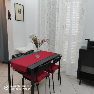 una mesa negra con un mantel rojo y sillas en La casa di Antonia, en Catania