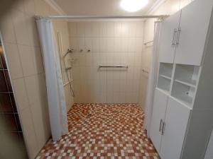 baño con ducha y suelo de baldosa. en Ferienwohnung "Zwei Finken" in der Blumenstadt Wiesmoor, en Wiesmoor