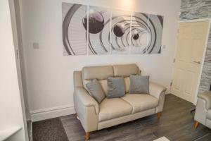 a living room with a couch and paintings on the wall at Pass the Keys Stylish 5 bed near major companies in Nottingham