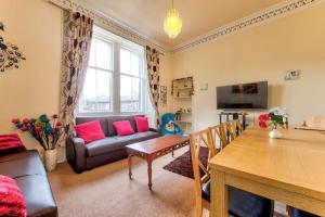 - un salon avec un canapé et une table dans l'établissement Edinburgh Morrison Central ApartHotel, à Édimbourg