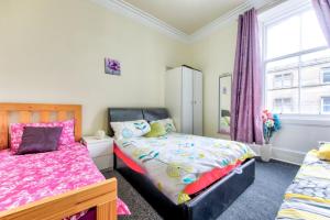 sypialnia z 2 łóżkami i oknem w obiekcie Edinburgh Morrison Central ApartHotel w Edynburgu