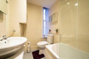 La salle de bains est pourvue de toilettes, d'un lavabo et d'une douche. dans l'établissement Edinburgh Morrison Central ApartHotel, à Édimbourg