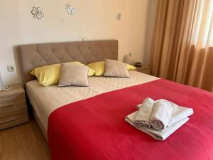 a bedroom with a large bed with two towels on it at 4 Sisters Apartments in Gradac