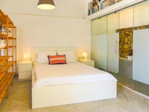 a bedroom with a white bed and two night stands at Oza Boutique hotel in Gümüşlük