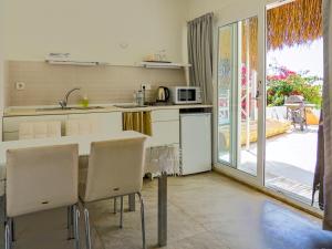 a kitchen with a table and chairs and a door to a patio at Oza Boutique hotel in Gümüşlük