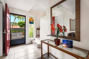 a hallway with a mirror and a table with flowers on it at Keauhou Kona Surf and Racquet Club Townhouse# 185 in Kailua-Kona