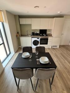 eine Küche mit einem schwarzen Tisch und Stühlen sowie eine Küche mit einem Tisch und Stühlen in der Unterkunft Richmond Row Apartments in Liverpool