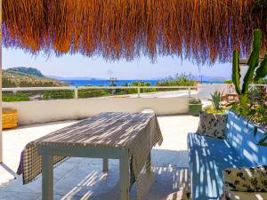 a patio with a table and a straw roof at Oza Boutique hotel in Gümüşlük