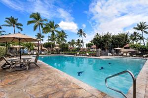 a pool at a resort with a table and chairs at Keauhou Kona Surf and Racquet Club Townhouse# 185 in Kailua-Kona