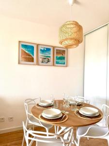 comedor con mesa de madera y sillas blancas en Bellissimo Appartamento Vistamare, en Antibes