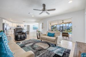 a living room with a couch and a ceiling fan at Amazing Water View with heated salt water pool - Villa Riverside - Roelens Vacations in Cape Coral