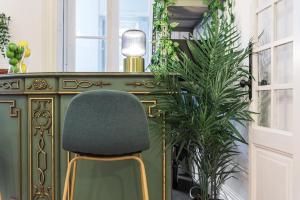een groene stoel naast een tafel met een plant bij GuestReady - Mola Green in Porto