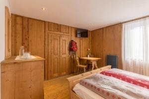 a bedroom with wooden walls and a bed and a table at Historic Hotel Ristorante La Stua in Cavalese