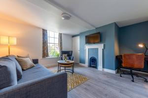 uma sala de estar com um sofá e uma lareira em Pass the Keys Garden View at The Iron House em Broseley