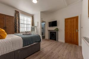 um quarto com uma cama grande e uma lareira em Pass the Keys Garden View at The Iron House em Broseley