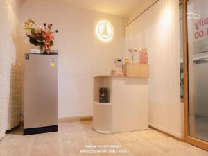 a room with a refrigerator and a shelf with flowers at Super OYO Capital O 564 Nature Boutique Hotel in Bangkok