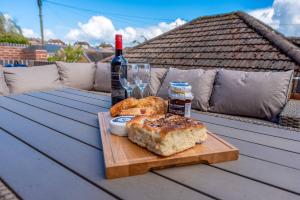 een tafel met een fles wijn, brood en wijnglazen bij Pass the Keys Garden View at The Iron House in Broseley