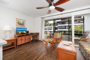 een woonkamer met een bank en een plafondventilator bij Casa De Emdeko 204 in Kailua-Kona