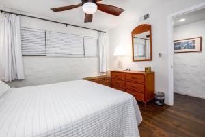 a bedroom with a white bed and a ceiling fan at Casa De Emdeko 204 in Kailua-Kona