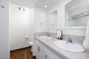 een witte badkamer met 2 wastafels en een spiegel bij Casa De Emdeko 204 in Kailua-Kona +17 foto's