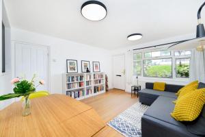 een woonkamer met een blauwe bank en een tafel bij Beautiful 1BR Flat in The Heart of Croydon in Croydon