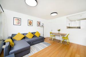 een woonkamer met een blauwe bank en een tafel bij Beautiful 1BR Flat in The Heart of Croydon in Croydon
