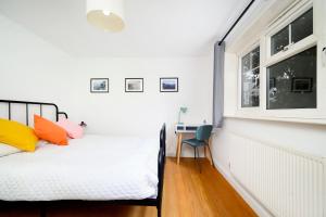 een slaapkamer met een bed, een bureau en een raam bij Beautiful 1BR Flat in The Heart of Croydon in Croydon