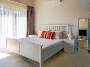 a bedroom with a white bed with pillows and a mirror at Oza Boutique hotel in Gümüşlük