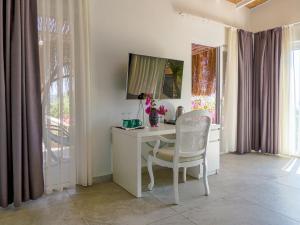 a room with a desk with a chair and a television at Oza Boutique hotel in Gümüşlük