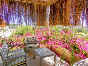 a patio with two chairs and a bunch of flowers at Oza Boutique hotel in Gümüşlük