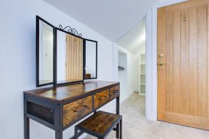 baño con tocador con espejo y taburete en Spacious Upstairs Bedroom Ensuite with Free Parking - Room 4 en Brentwood