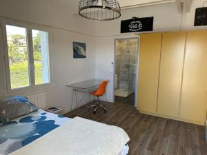 - une chambre avec un lit, un bureau et une table dans l'établissement Belle Villa, piscine chauffée à 250m des plages, à Biarritz