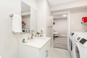a white bathroom with a washing machine and a sink at Bright 4 BR Family Home , Sleeps 8, Near Wonderland and Vaughan Mills in Vaughan +35 photos
