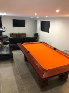 - un salon avec une table de billard orange dans l'établissement Belle Villa, piscine chauffée à 250m des plages, à Biarritz