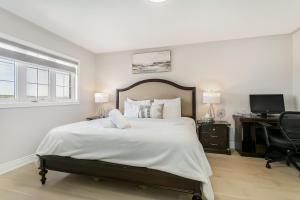 a bedroom with a bed and a desk with a computer at Pristine Pet & Smoke Free 4-Bedroom home near Canada's Wonderland in Vaughan