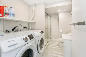 a white laundry room with a washing machine at Bright 4 BR Family Home , Sleeps 8, Near Wonderland and Vaughan Mills in Vaughan