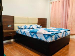 a bedroom with a bed with blue sheets and blue pillows at RIGS Homestay in Gangtok