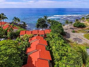 an orange roofed house with the ocean in the background at Keauhou Kona Surf & Racket Club Townhouse #3 in Kailua-Kona