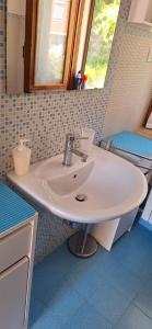 La salle de bains est pourvue d'un lavabo blanc et d'une fenêtre. dans l'établissement Rifugio collina del Sacro Cuore, à Ascoli Piceno