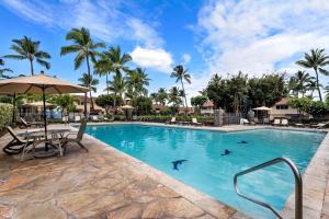 a pool at a resort with a table and chairs at Keauhou Kona Surf & Racket Club Townhouse #3 in Kailua-Kona