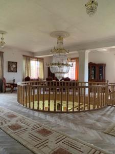 Habitación grande con lámpara de araña y escalera. en Hotel Villa DavidL, en Sagarejo