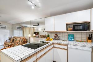 a kitchen with white cabinets and a sink at Kona Isle A4 in Kailua-Kona