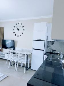 a kitchen with a table and a clock on the wall at 4 season Apartment in Lezhë