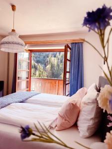 a bedroom with a bed with a window and flowers at Gasthof Arriach in Arriach