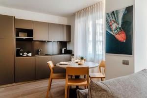 Una cocina y un comedor con mesa y sillas. en Rubini Suites - by MyHomeInComo, en Como