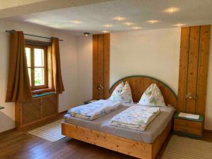 una camera da letto con un letto con testiera in legno e una finestra di Ferienwohnung Schreiner a Wernstein am Inn